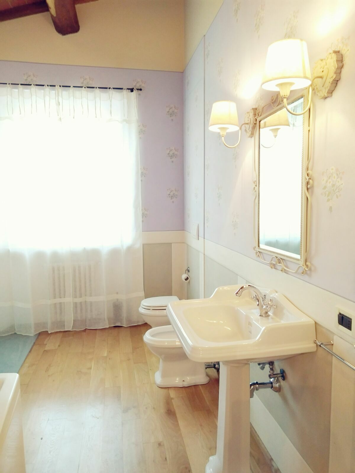 A bathroom with a toilet, sink, and mirror.