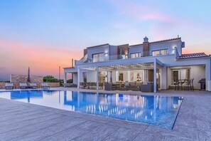 A modern house with a swimming pool, outdoor seating, and a patio area. - Goldeneye Luxury 6 Bedroom luxury Villa With Infinity Pool sea view (Lagoa)