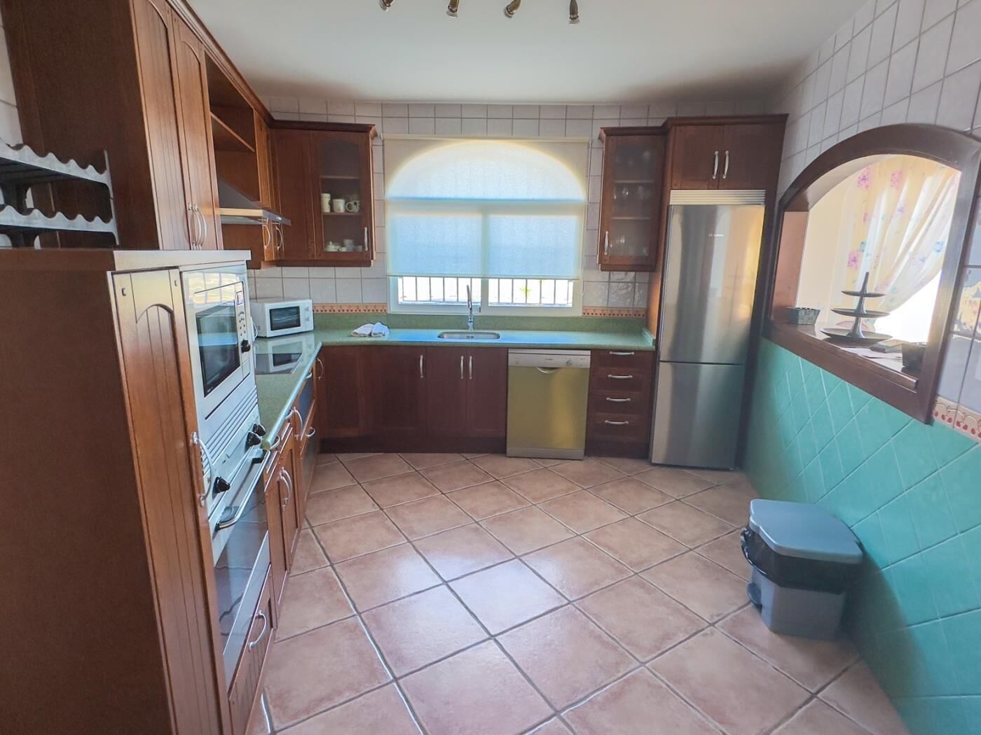 A kitchen with wooden cabinets, a microwave, a dishwasher, and a refrigerator.