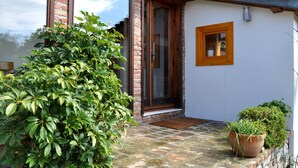 A brick house with a wooden door, a small window, and a potted plant on the porch. - Garden House, Ephesus Holiday Rentals (Selçuk)