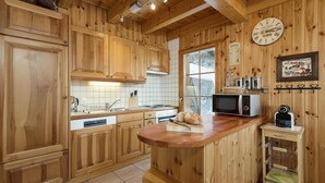 Eine Holz-Küche mit einer zentralen Kochinsel, einer Mikrowelle und einem kleinen Kühlschrank.