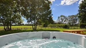 A hot tub in a natural setting with trees and a picnic table. - The Cotswold Manor Vineyard, Exclusive Hot Tub, Games Barn, 70 acres of Parkland (Bampton)