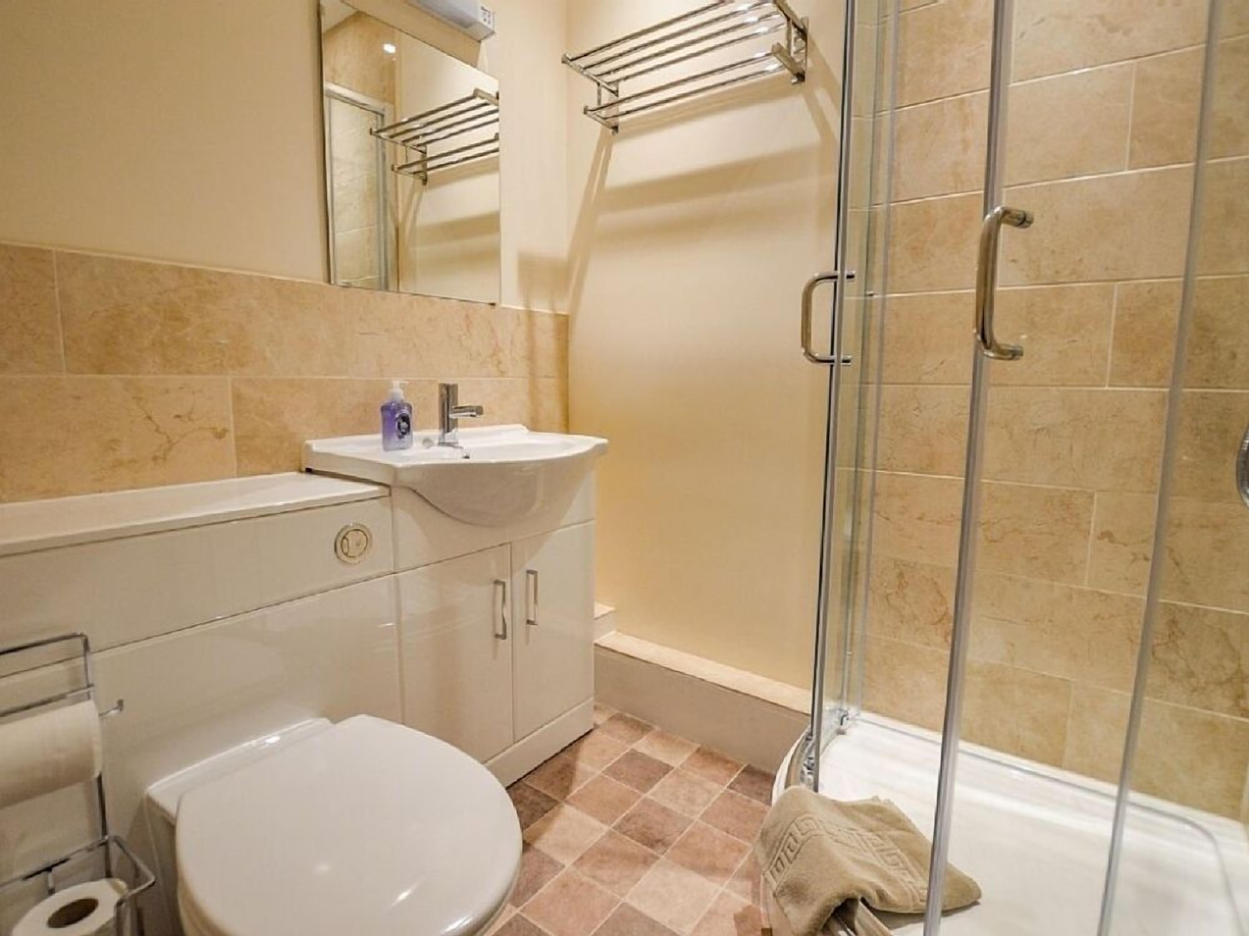 Une salle de bain avec des toilettes, un lavabo et une douche.