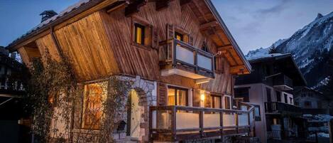 Eine Holzchalet mit Balkon, Stein Fundament und Bergblick.