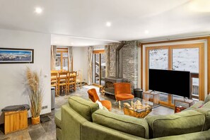 Un salon moderne avec une cheminée, un téléviseur et un coin repas doté de meubles en bois.