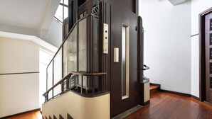 Uma escadaria moderna com guarda-corrimão de vidro e porta com puxador.