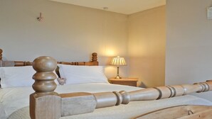 A neatly made bed with a wooden headboard and footboard, a bedside lamp, and a small bedside table. - Detached Rural Cottage in Idyllic Location with 3 acre safe secure 6ft dog field (Bradnop)
