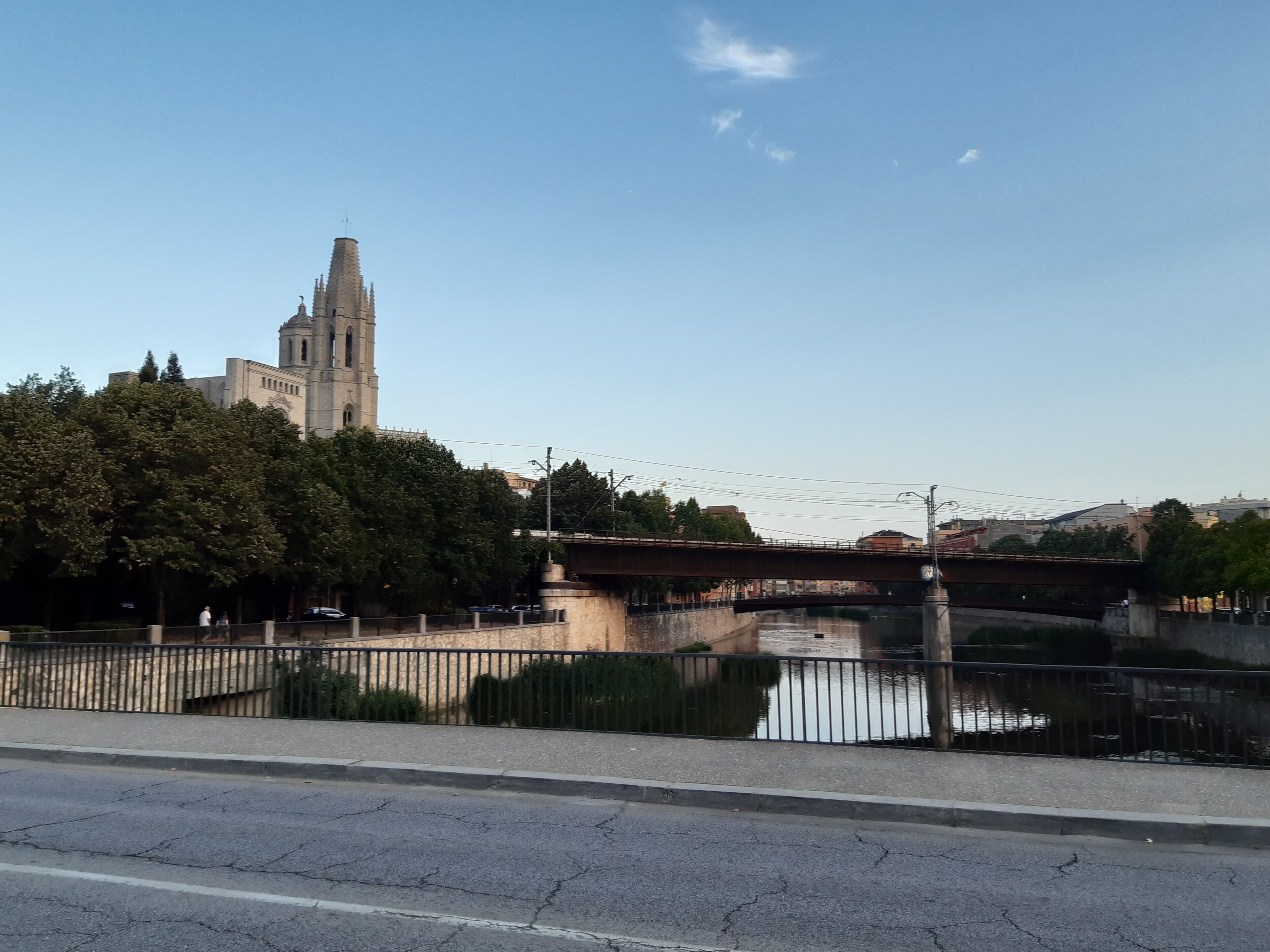 A river with a bridge, a tall tower, and trees along the riverbank.