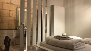 A modern bedroom with a bed, a nightstand, and a chair. - Charming house with swimming pool and air conditioning 15 minutes from Bordeaux (Saint-Caprais-De-Bordeaux)