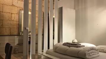 A modern bedroom with a bed, a nightstand, and a chair.