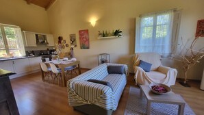 Una sala acogedora con un sofá, una mesa de comedor y una cocina al fondo.