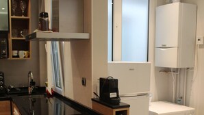 A compact kitchen with a central island, built-in appliances, and a laundry area. - Apartment near Gros beach, ESS00033 (San Sebastián)