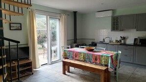A spacious kitchen with a dining area, a staircase, and a view of the outdoors. - Cottage with private garden in wooded property with swimming pool (Pertuis)