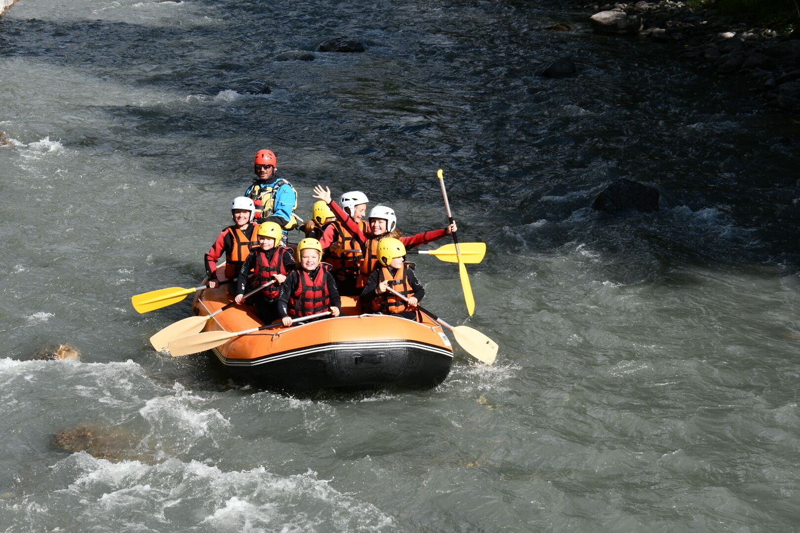 Un groupe de personnes à bord d’un radeau qui descend une rivière.