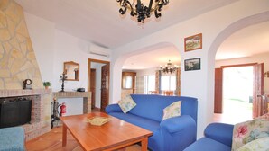 Ein Wohnzimmer mit blauem Sofa, Couchtisch aus Holz und Kamin.