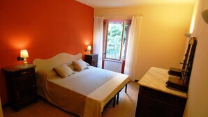 A bedroom with a bed, bedside tables, a dresser, and a window with curtains. - CENTRALLY quiet and typical residence -150 mt. from the sea (Levanto)