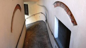 A narrow stairway with a textured wall and a small window at the top. - CENTRALLY quiet and typical residence -150 mt. from the sea (Levanto)