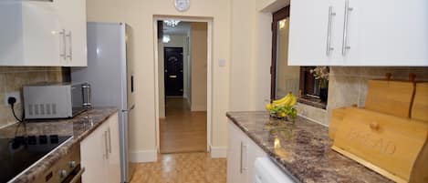 Een microgolfoven, een vaatwasser, kookgerei, borden en bestek