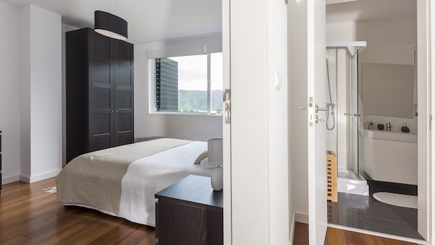 A bedroom with a bed, a wardrobe, and a bathroom with a shower and toilet. - House of the Camellias, modern constriction - Next to the City Gates (Sete Cidades)
