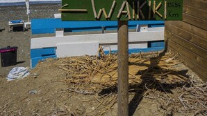 A wooden signpost with directions to Latsi, Free Showers, Changing Room, and Waikiki, with a beach and ocean in the background. - Villa Astro -  a beach villa with heated pool that sleeps 8 guests  in 4 bedrooms (Paphos)