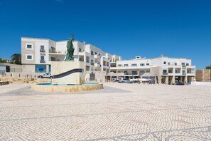 A modern building with a central fountain and a statue.