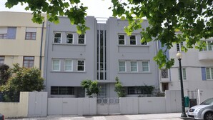 A modern building with a symmetrical facade, multiple windows, and a central vertical feature.
