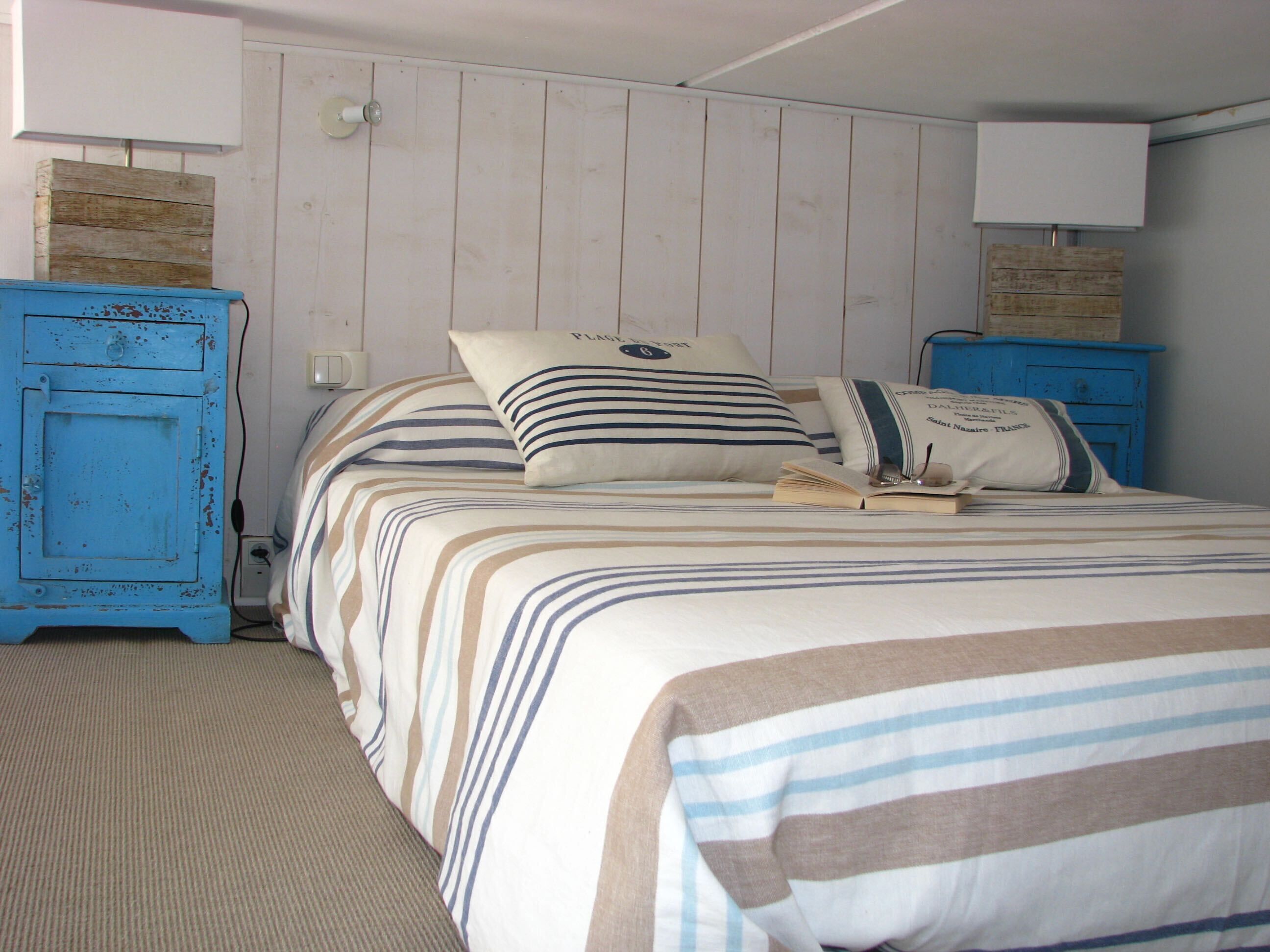 A bedroom with a bed, two nightstands, and a lamp.