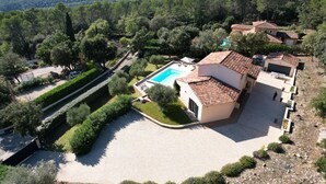 Eine Villa mit Swimmingpool, umgeben von angelegten Gärten und Blick auf die Landschaft.