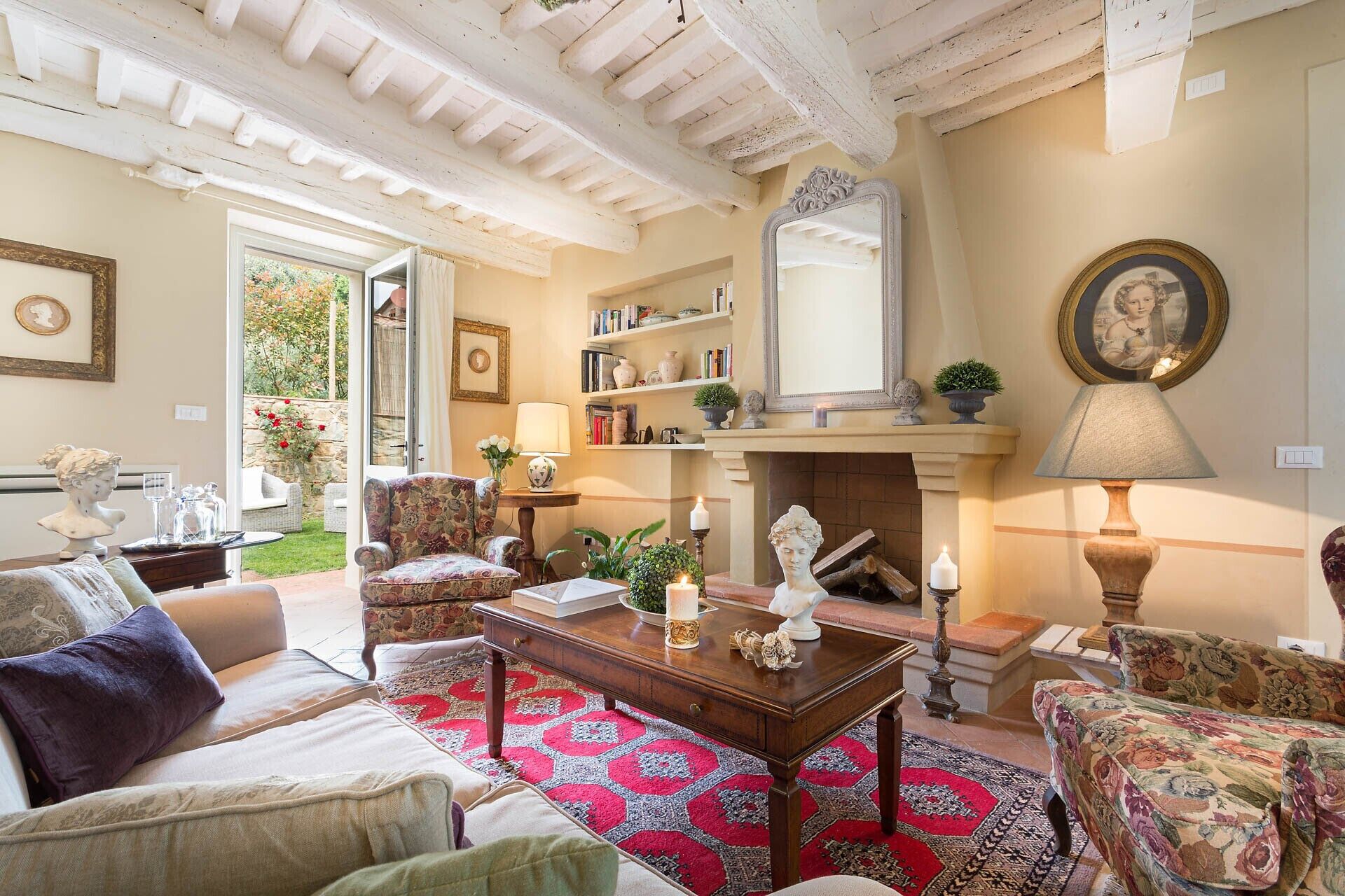 A cozy living room with a fireplace, comfortable seating, and a view of the garden.