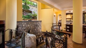 A staircase with a stone wall, a view of greenery, and a dining area with a lamp. - Villa Turtle with sea view and  private pool (Massa Lubrense)