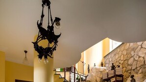A grand staircase with stone walls, a chandelier, and statues. - Villa Turtle with sea view and  private pool (Massa Lubrense)