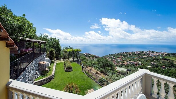 A balcony with a stone wall, a garden with a lawn and a pergola, and a coastal view. - Villa Turtle with sea view and  private pool (Massa Lubrense)