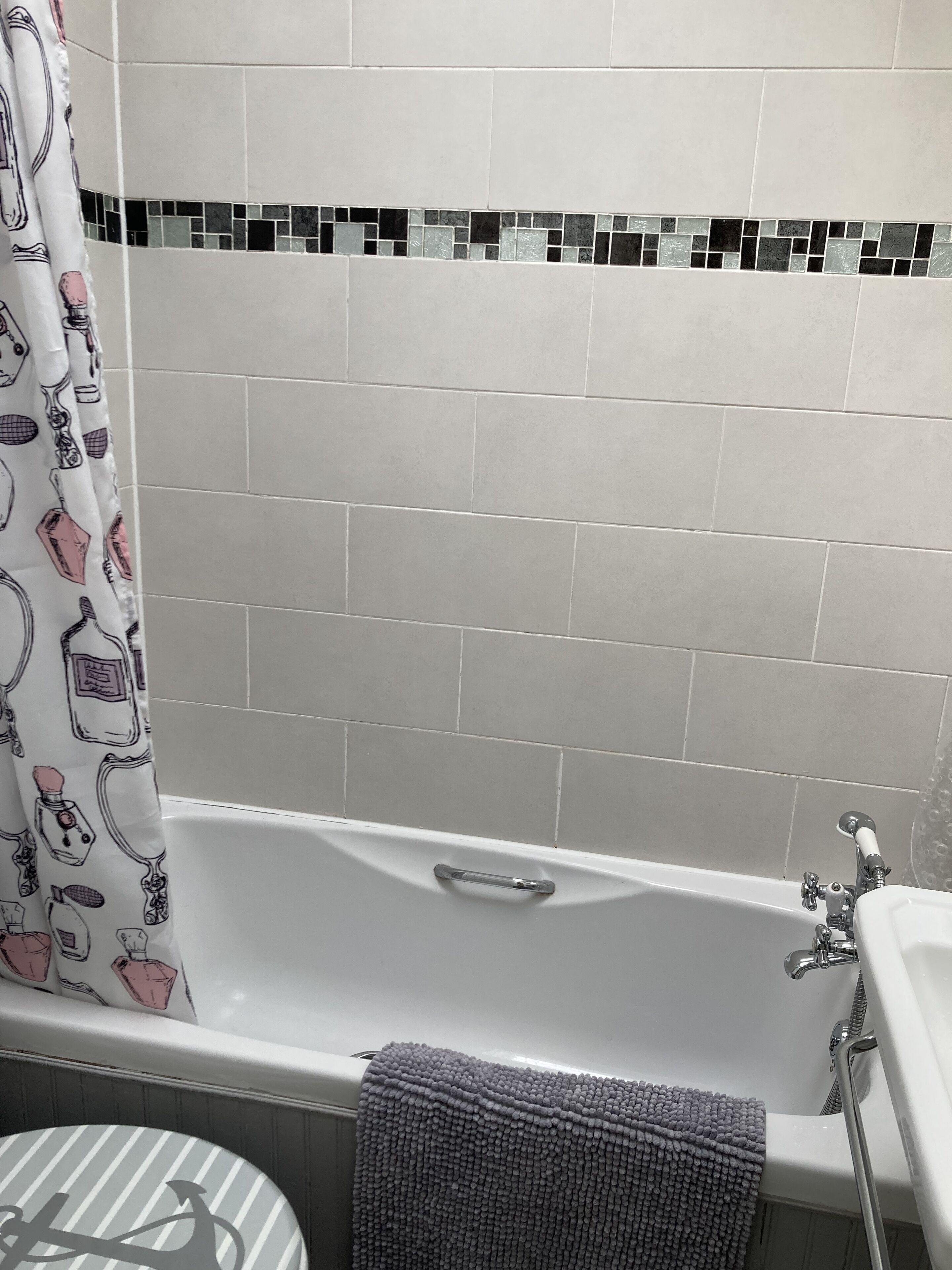 Een bad/douchecombinatie, een haardroger, handdoeken, zeep