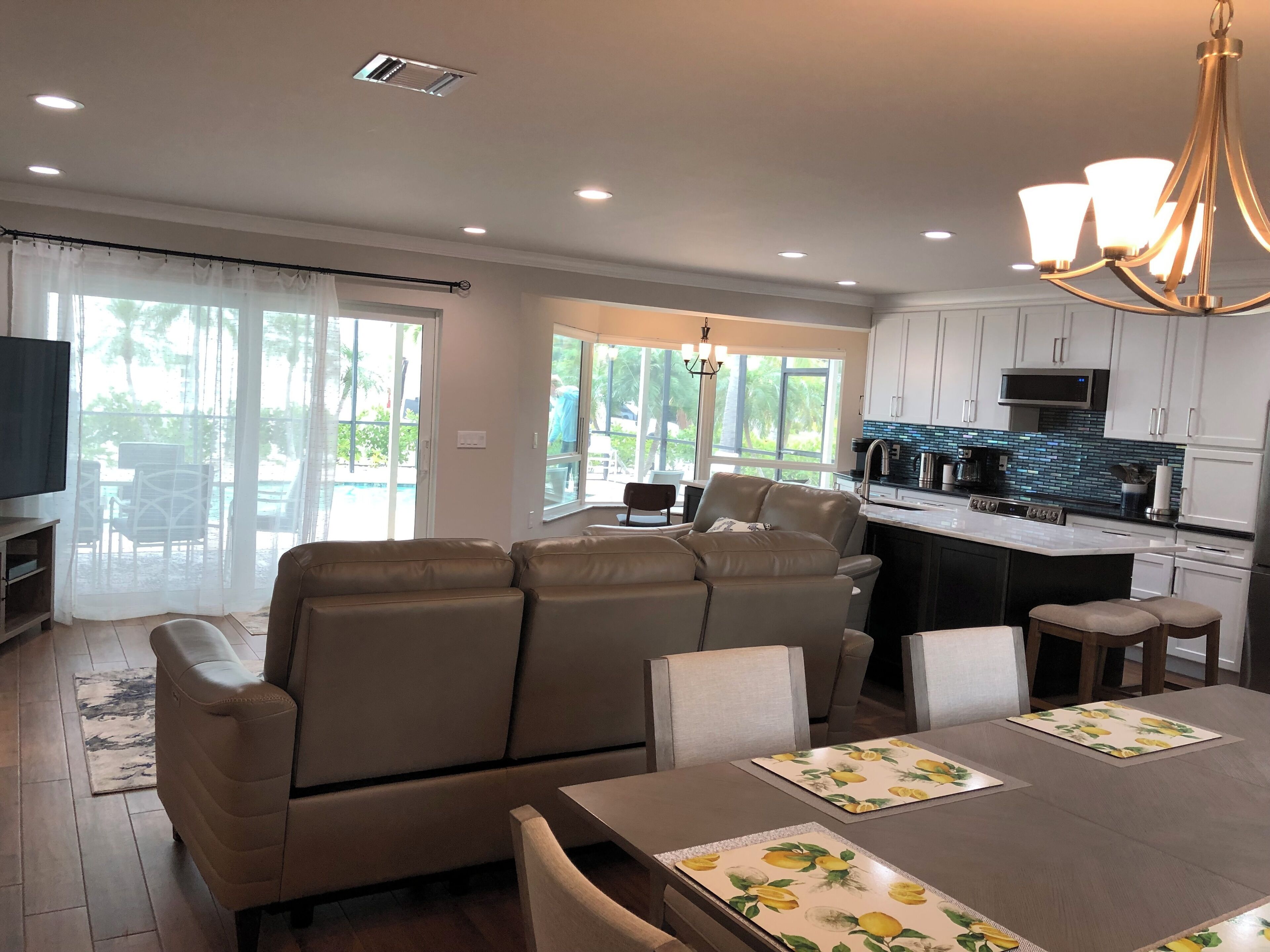 A modern living room with a sofa, dining table, and kitchen area.