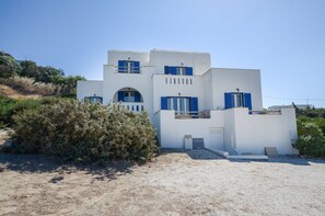 Un bâtiment blanc avec des volets bleus et un petit balcon.