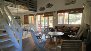 Ein geräumiger Wohnbereich mit Treppe, einem Esstisch und einer Couch.
