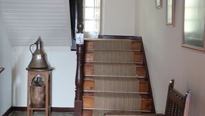 Un escalier avec une rampe en bois et une chaise en bas.