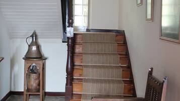 Un escalier avec une rampe en bois et une chaise en bas.