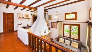 A cozy interior with a fireplace, wooden beams, a sofa, and a dining area. - GARROVERA - Beautiful Finca for 8 persons in Pollensa (Pollensa / Pollença)