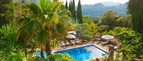 Een buitenzwembad en ligstoelen