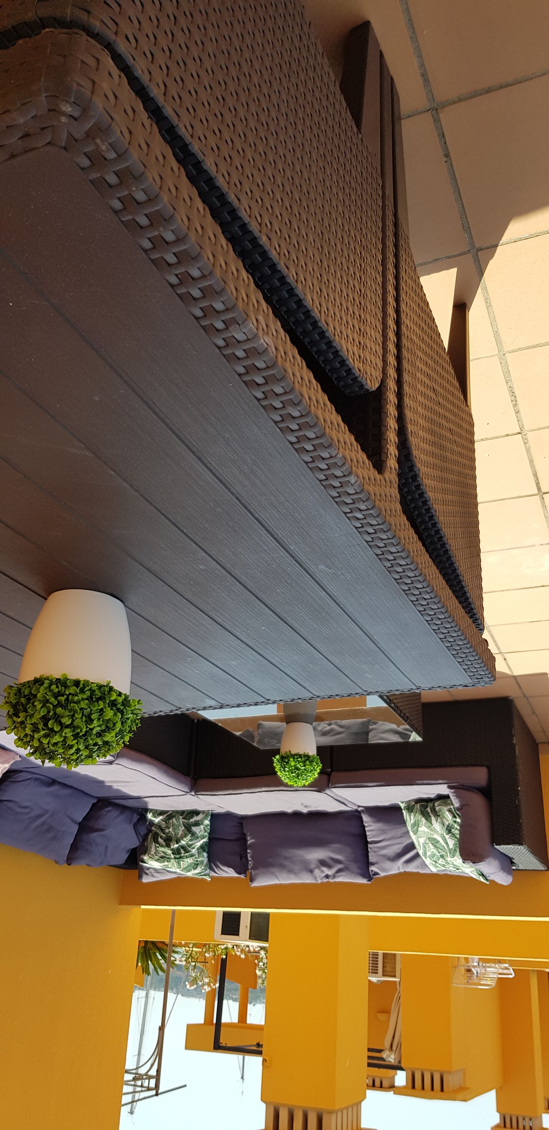 A high ceiling with a textured wall and a large window.