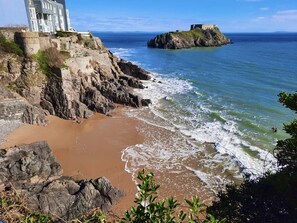 A coastal landscape with a historic building and a fort on a rocky outcrop. - Architect Designed Stunning House, In Quiet And Peaceful Stunning Location  (Tenby. Pembrokeshire)