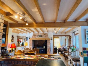 Cozy living area with a central fireplace, checkered floor, and wooden furniture.