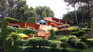 A hillside villa with terraced gardens, a stone wall, and a red roof. - Flat - 2 rooms - 4 persons (Sanary-Sur-Mer)