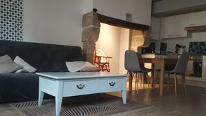 A living room with a sofa, a coffee table, and a dining area with chairs and a table. - Charming apartment on the 1st floor, St Goustan port of Auray. (Auray)