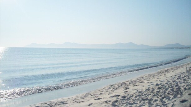 A beach with clear water and distant mountains. - Country house with private pool and panoramic views and accessible (Santa Margalida)