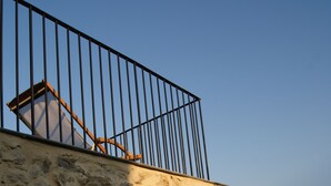 A stone wall with a metal railing overlooking a mountainous landscape. - Gîte Nature In Aveyron (La Bastide-Pradines)