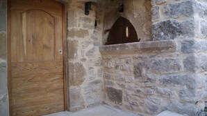 A stone wall with a wooden door and a small arched window. - Gîte Nature In Aveyron (La Bastide-Pradines)