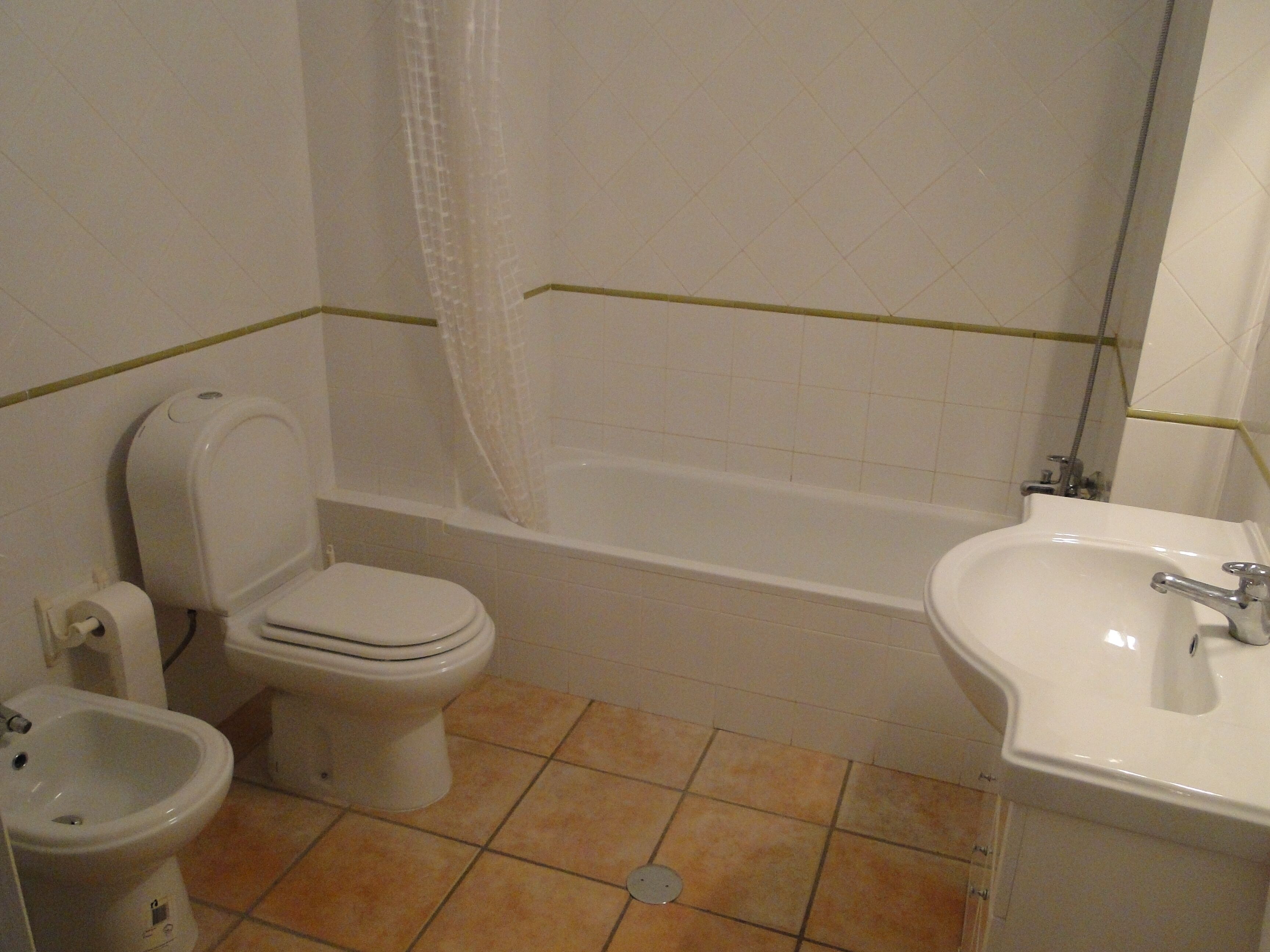 Un baño con inodoro, bidé, bañera y lavamanos.