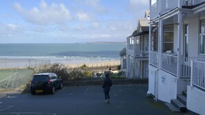 A coastal building with a view of the beach. - Harbour View Apartment has stunning views of St Ives harbour and beaches. (St Ives)